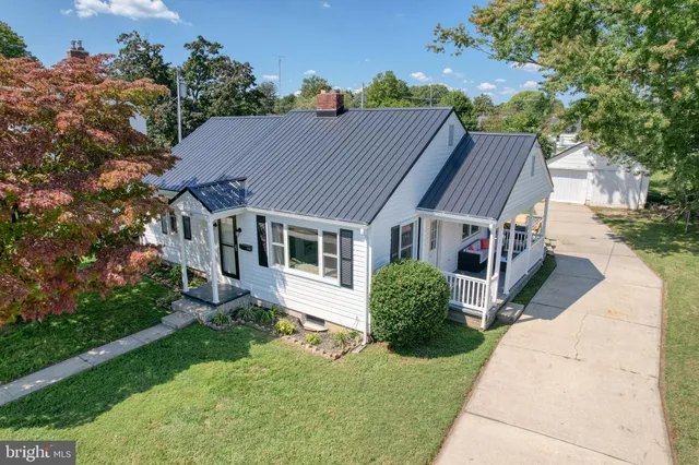 a aerial view of a house with yard porch and furniture