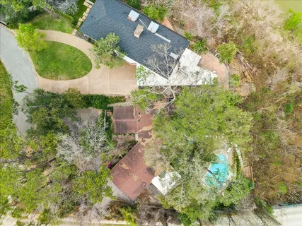 an aerial view of residential house with outdoor space and trees all around
