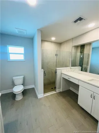 a bathroom with a double vanity sink toilet and shower