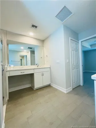 a bathroom with a double vanity sink mirror and tub