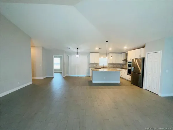 a view of kitchen with refrigerator stove and cabinets