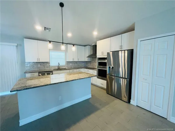 a large kitchen with a refrigerator a sink and a stove
