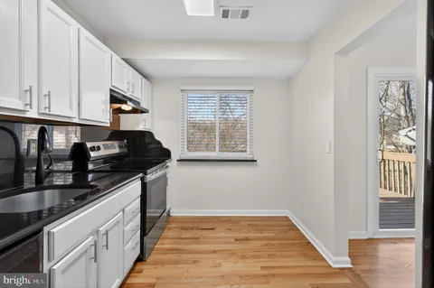 a kitchen with granite countertop a sink stove and cabinets