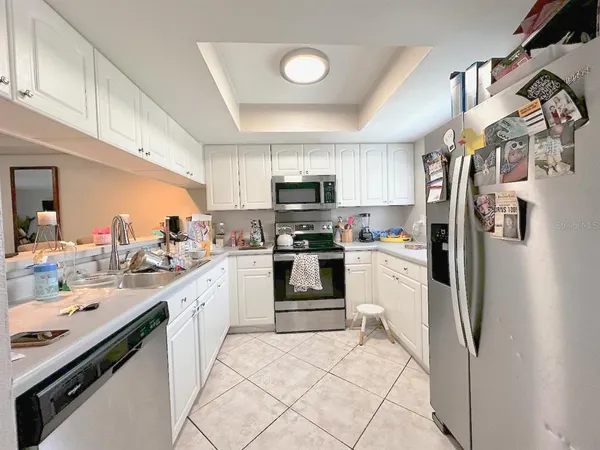 a kitchen with stainless steel appliances granite countertop a refrigerator stove and sink