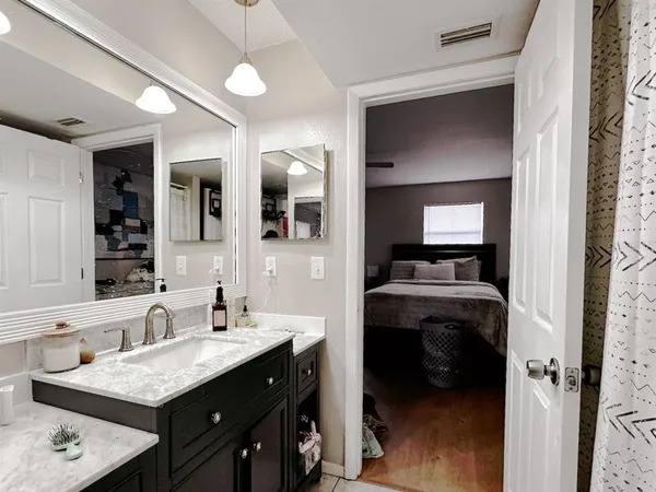 a en suite bathroom with a granite countertop sink and a mirror