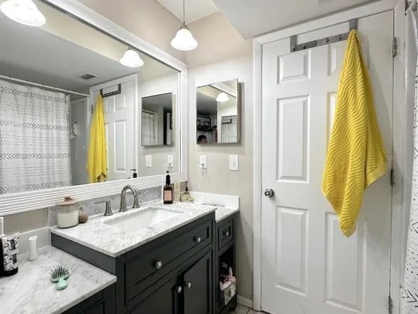 a bathroom with a granite countertop sink and a mirror