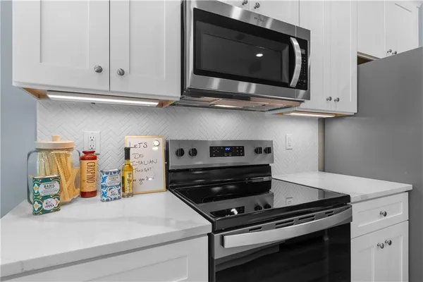 a kitchen with sink refrigerator and couches