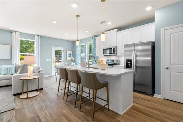 a kitchen with kitchen island a dining table and chairs