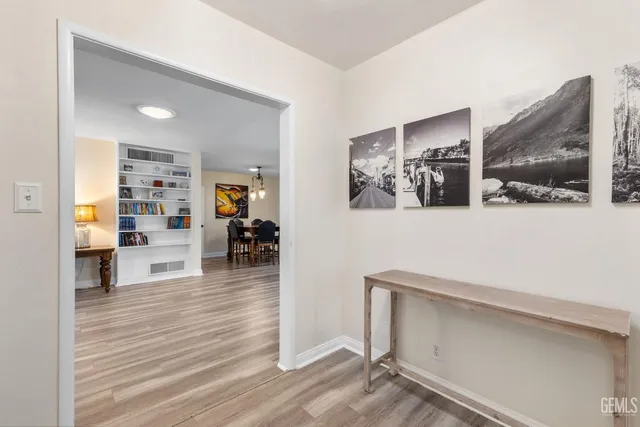 a view of a livingroom with wooden floor and a fireplace