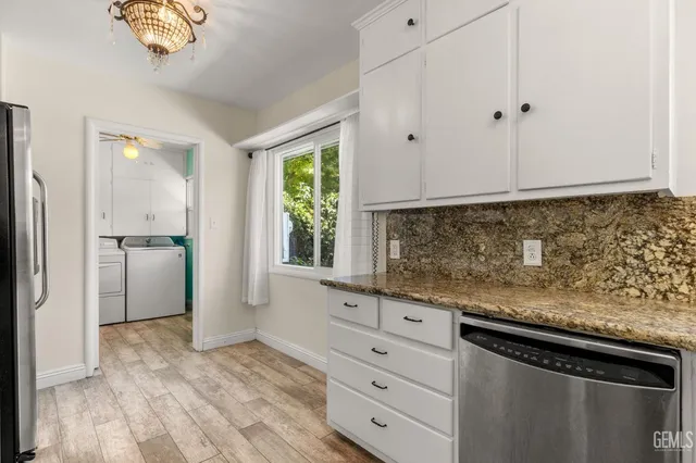 a kitchen with white cabinets and stainless steel appliances