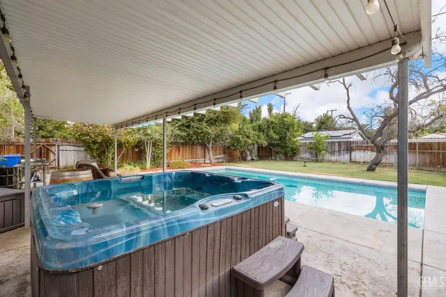 a view of a patio with table and chairs potted plants with wooden floor and fence