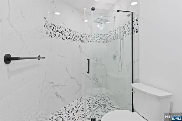 a bathroom with a shower a toilet and a sink