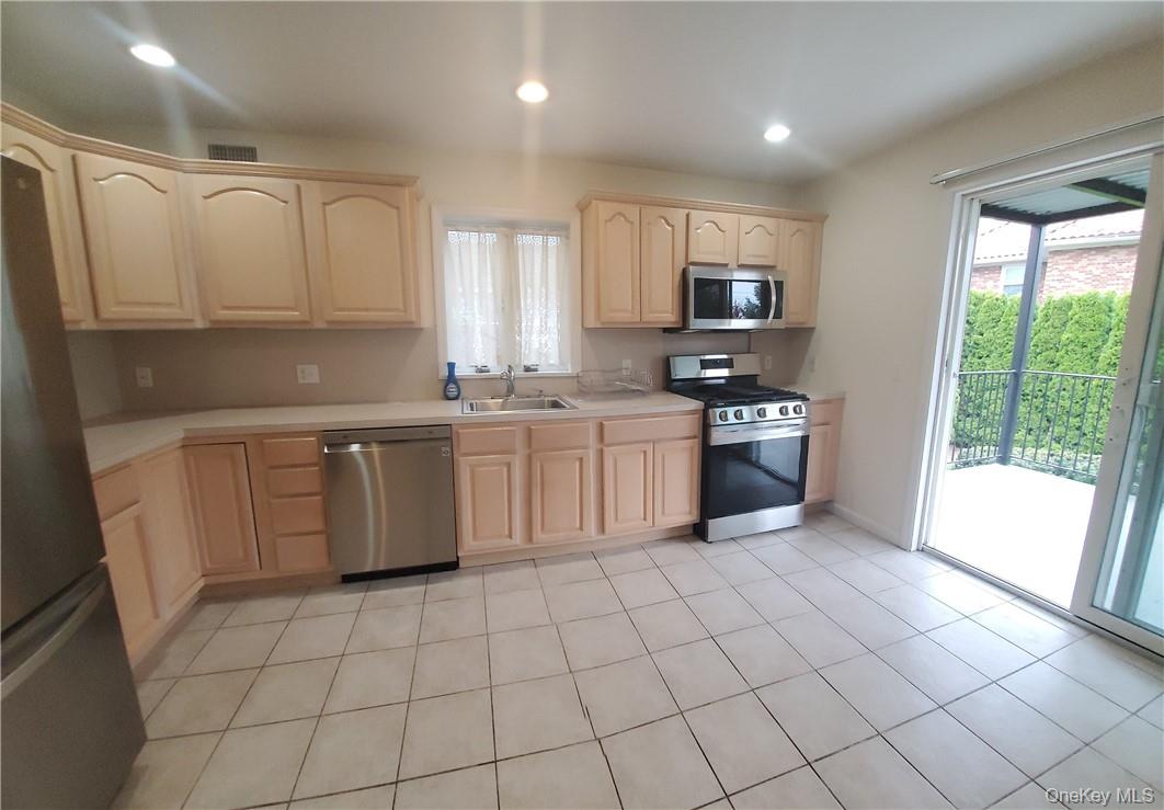 315 Washington Avenue, Unit 1 New Rochelle, NY 10801 - Photo 3 of 29 a kitchen with stainless steel appliances granite countertop a stove top oven a sink a counter top space cabinets and a window