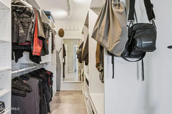 a view of walk in closet with clothes and shoes