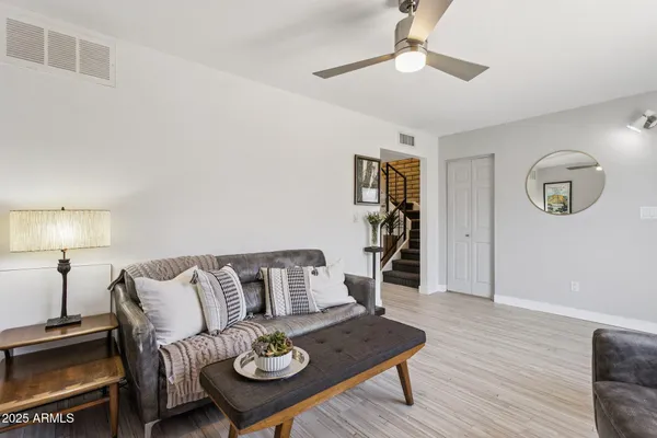 a living room with furniture and a wooden floor