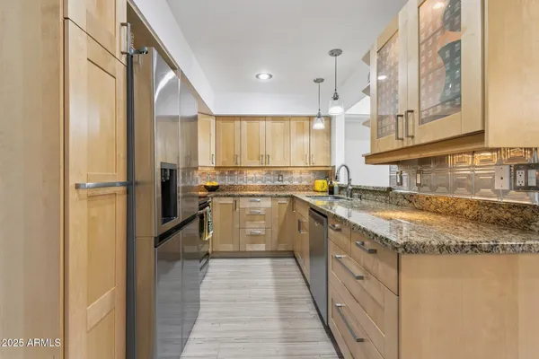 a kitchen with granite countertop a sink stainless steel appliances and cabinets