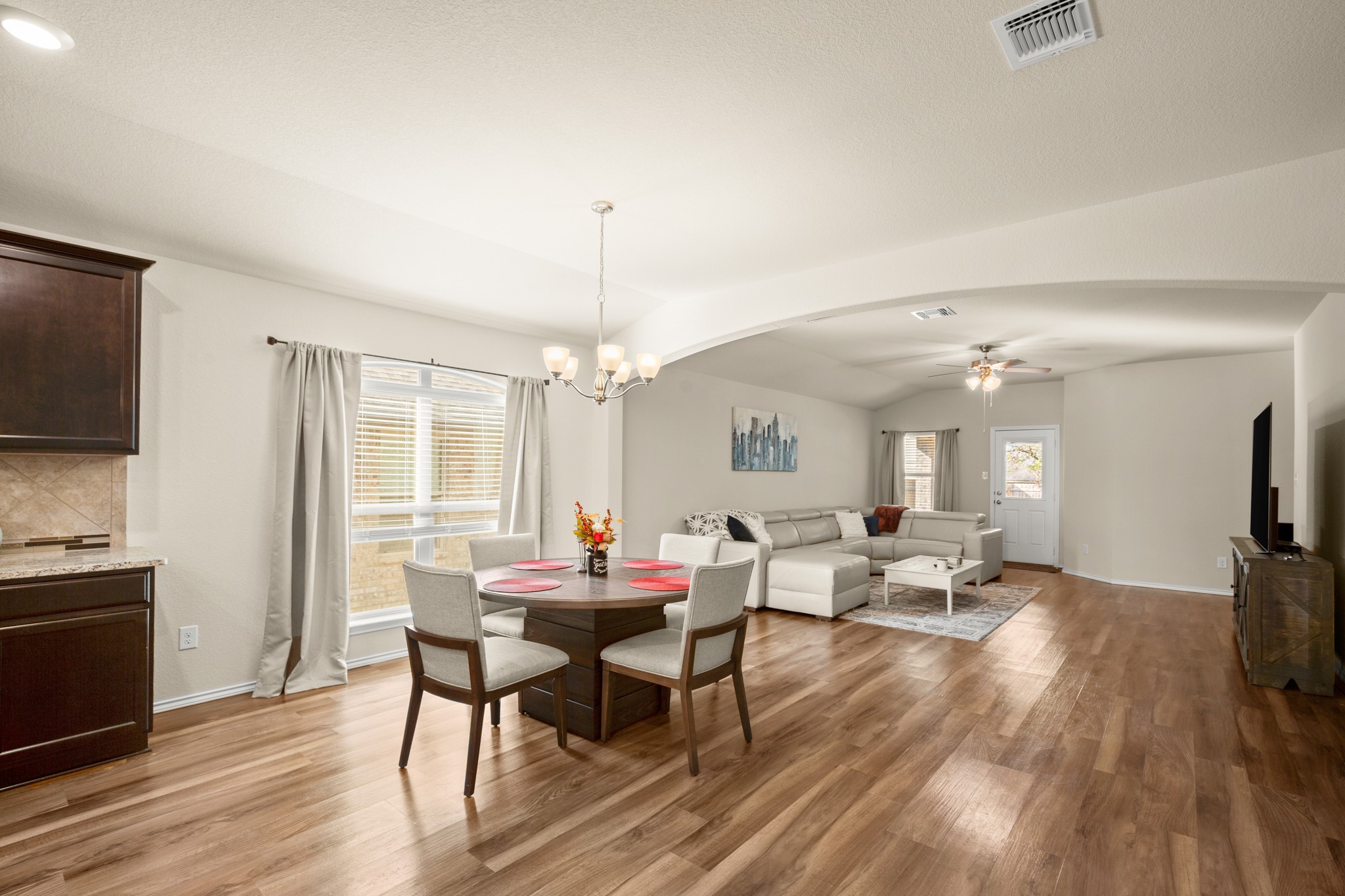 5526 Perdita Drive Belton, TX 76513 - Photo 3 of 26 Dining space with arched walkways, light wood-type flooring, ceiling fan, a chandelier, and vaulted ceiling