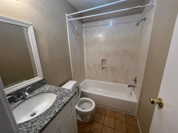 a bathroom with a granite countertop sink mirror vanity and bathtub