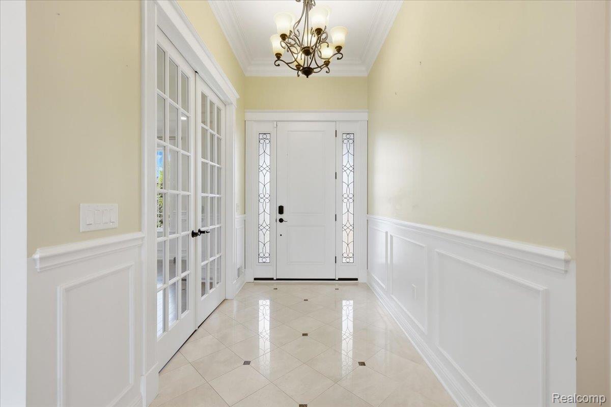35339 West 13 Mile Road Farmington, MI 48331 - Photo 5 of 72 Entrance foyer featuring ornamental molding, a decorative wall, wainscoting, light tile patterned floors, and a chandelier