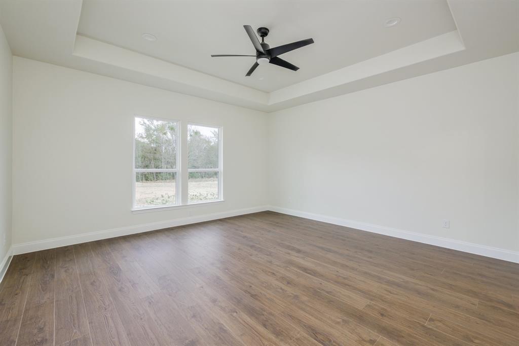 1844 County Road 2320 Terrell, TX 75160 - Photo 17 of 27 an empty room with wooden floor ceiling fan and windows