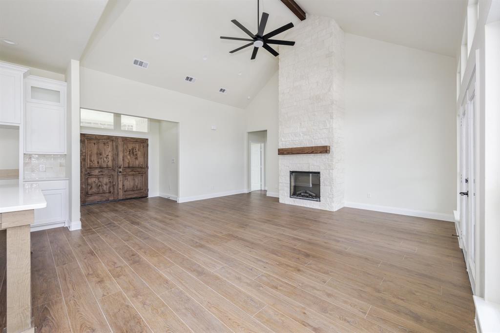 1844 County Road 2320 Terrell, TX 75160 - Photo 22 of 27 an empty room with wooden floor a ceiling fan and kitchen view