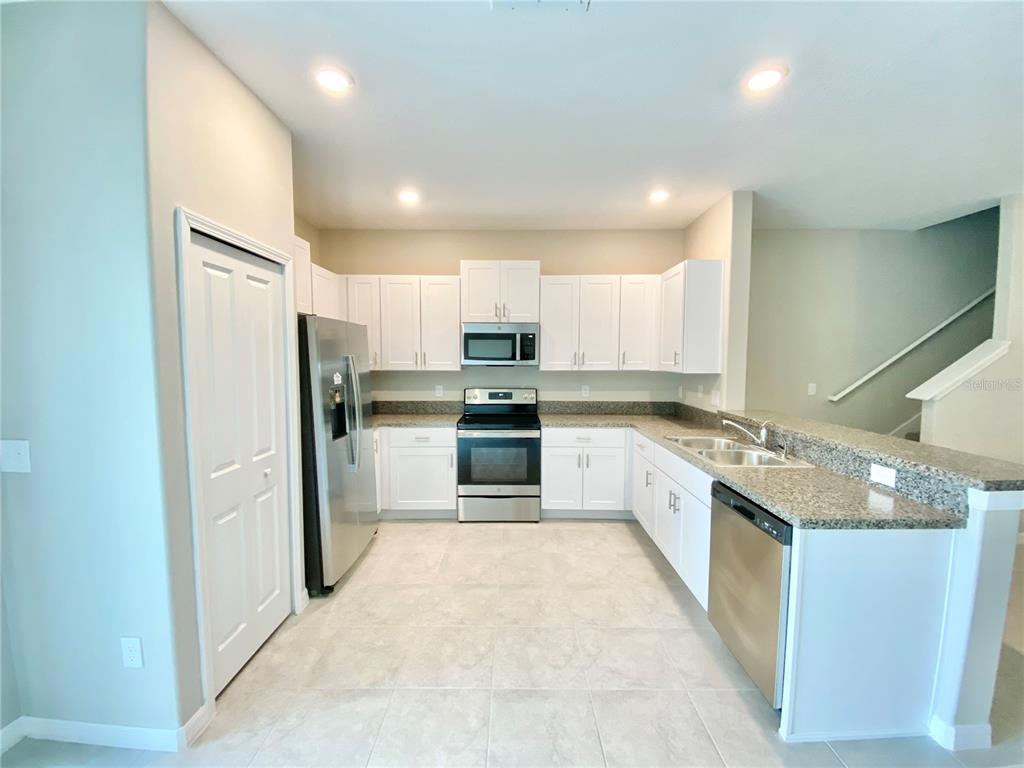 3523 Bellmeade Court Wesley Chapel, FL 33543 - Photo 5 of 22 a large kitchen with stainless steel appliances granite countertop a stove a refrigerator and a sink