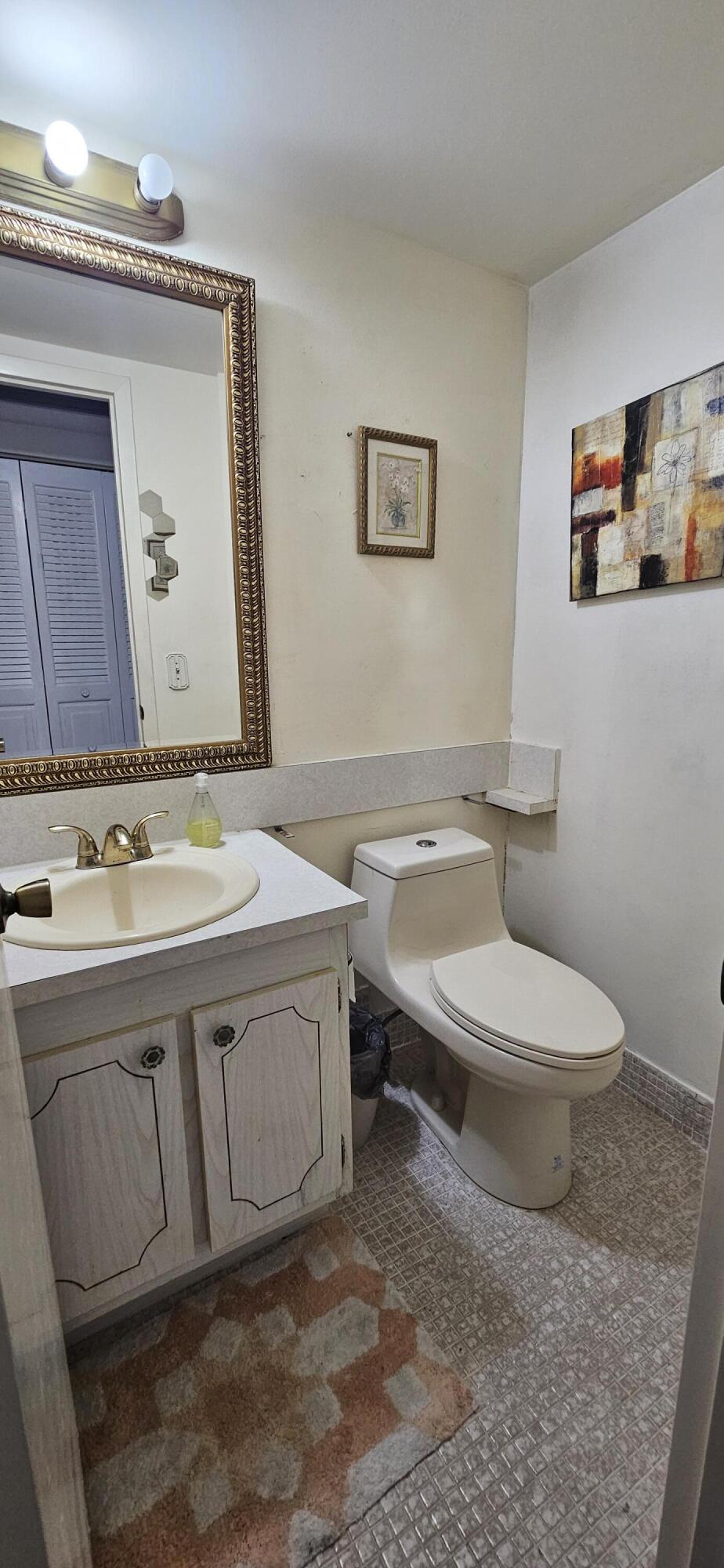 198 Preston Way, Unit 198 Boca Raton, FL 33434 - Photo 11 of 16 a bathroom with a toilet a sink and mirror
