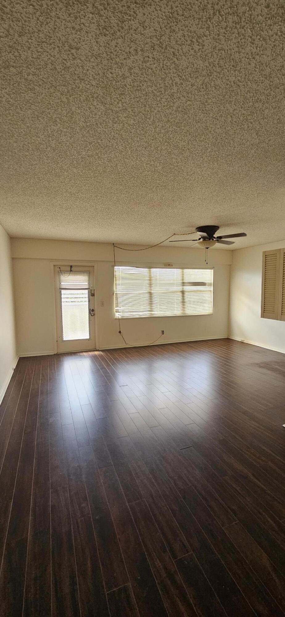 198 Preston Way, Unit 198 Boca Raton, FL 33434 - Photo 2 of 16 a view of empty room with wooden floor and fan