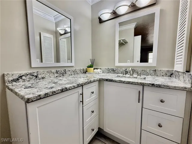 a bathroom with a granite countertop sink a toilet and a mirror