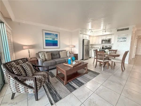 a living room with furniture and a dining table with kitchen view