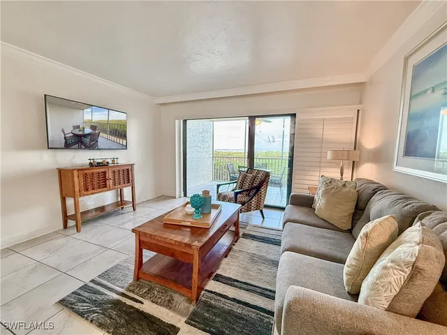 a living room with furniture a rug and a large window