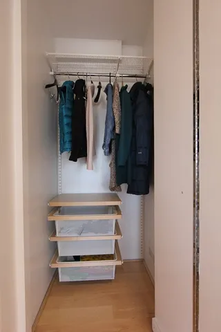 a view of walk in closet with clothes and shoes
