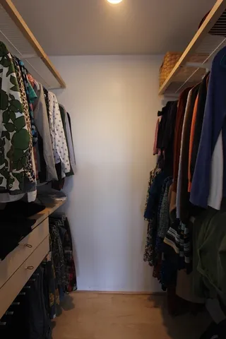 a view of walk in closet with clothes and shoes