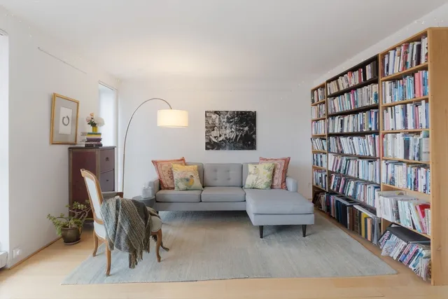 a living room with furniture and a book shelf