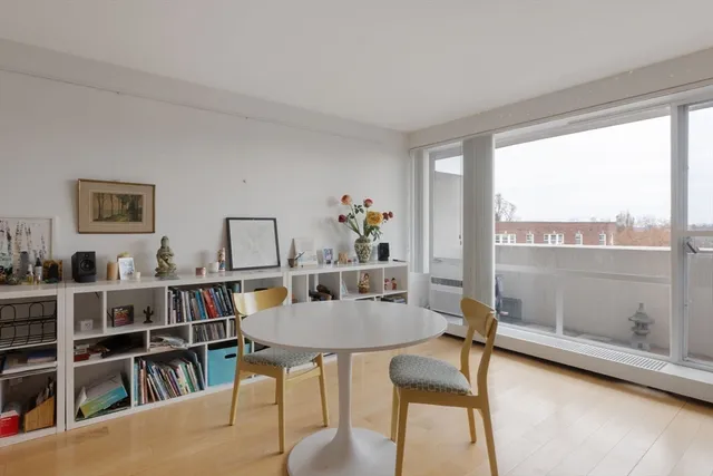 a view of a workspace with furniture bookshelf and a window