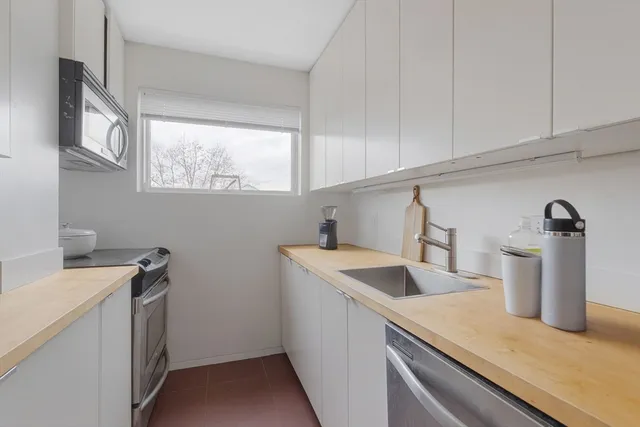 a kitchen with a sink cabinets and window