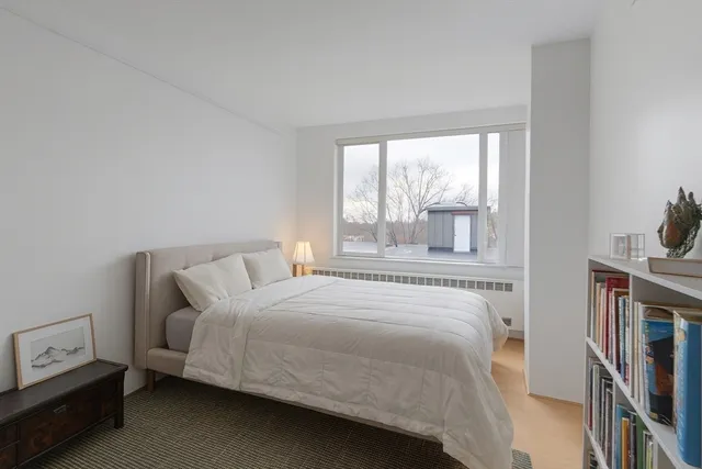 a bedroom with a bed next to a large window