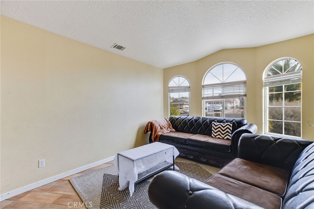 12794 Rain Shadow Road Victorville, CA 92395 - Photo 11 of 50 a living room with furniture and a large window
