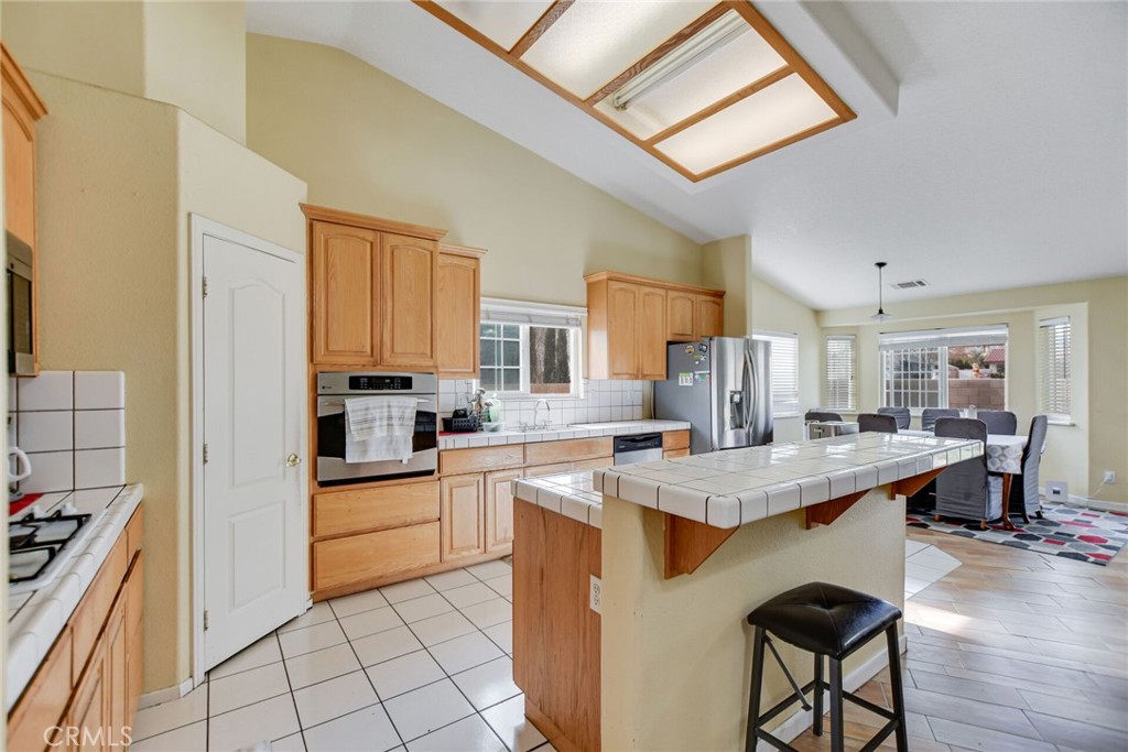 12794 Rain Shadow Road Victorville, CA 92395 - Photo 13 of 50 a kitchen with a stove a sink dishwasher and a refrigerator