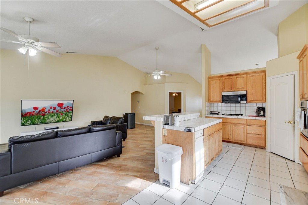 12794 Rain Shadow Road Victorville, CA 92395 - Photo 17 of 50 a kitchen with kitchen island granite countertop a stove top oven a sink a counter top space and cabinets