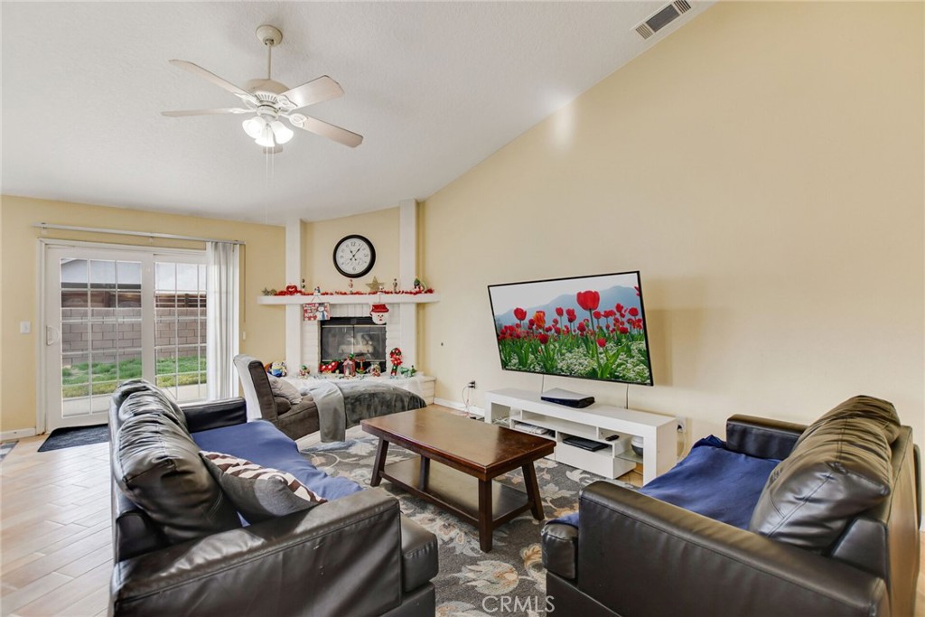 12794 Rain Shadow Road Victorville, CA 92395 - Photo 21 of 50 a living room with furniture a flat screen tv and a large window