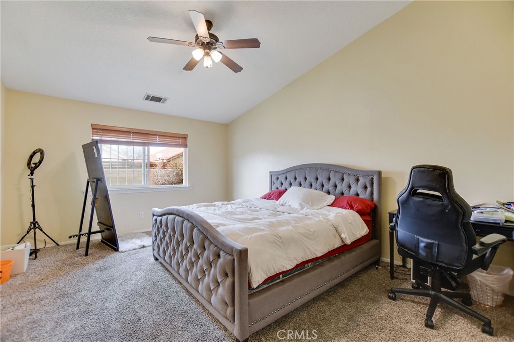 12794 Rain Shadow Road Victorville, CA 92395 - Photo 30 of 50 a bedroom with a bed and a chandelier