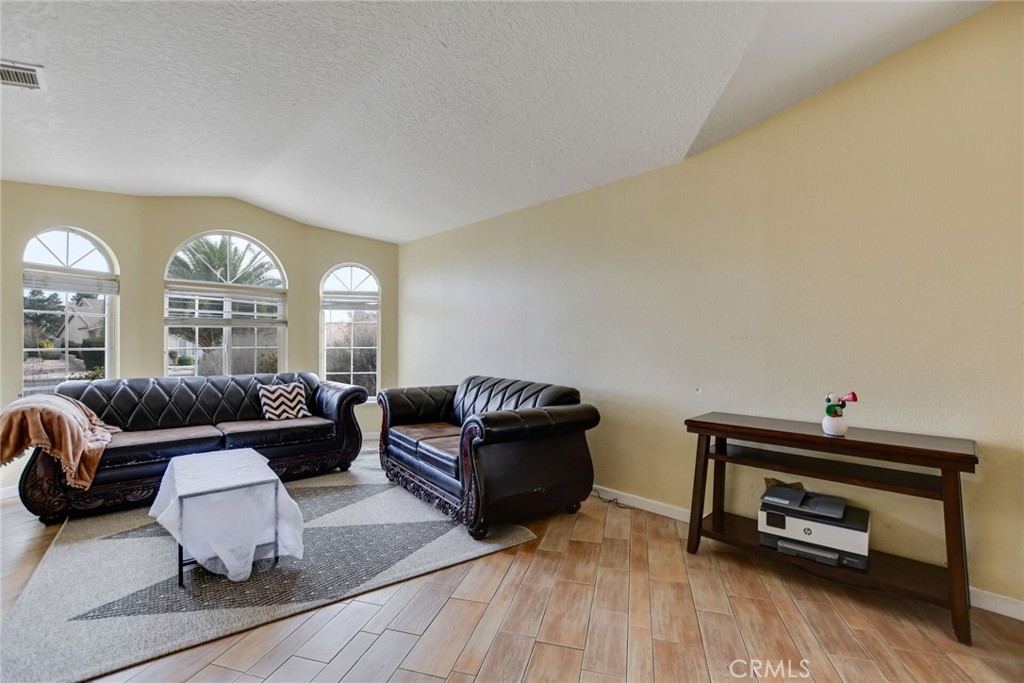 12794 Rain Shadow Road Victorville, CA 92395 - Photo 10 of 50 a living room with furniture and a wooden floor
