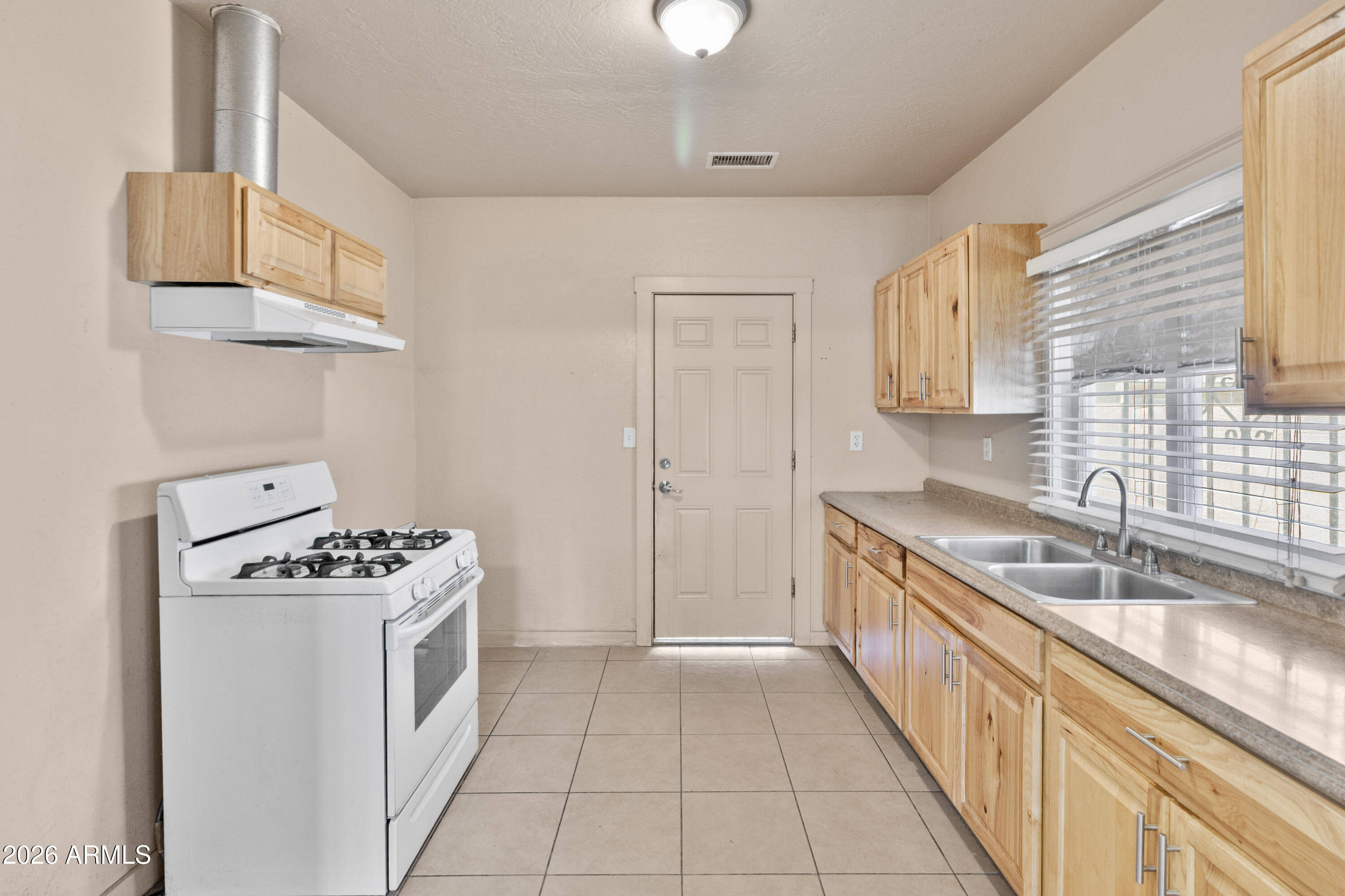 1237 East Pierce Street Phoenix, AZ 85006 - Photo 9 of 23 a kitchen with granite countertop a sink a stove and cabinets
