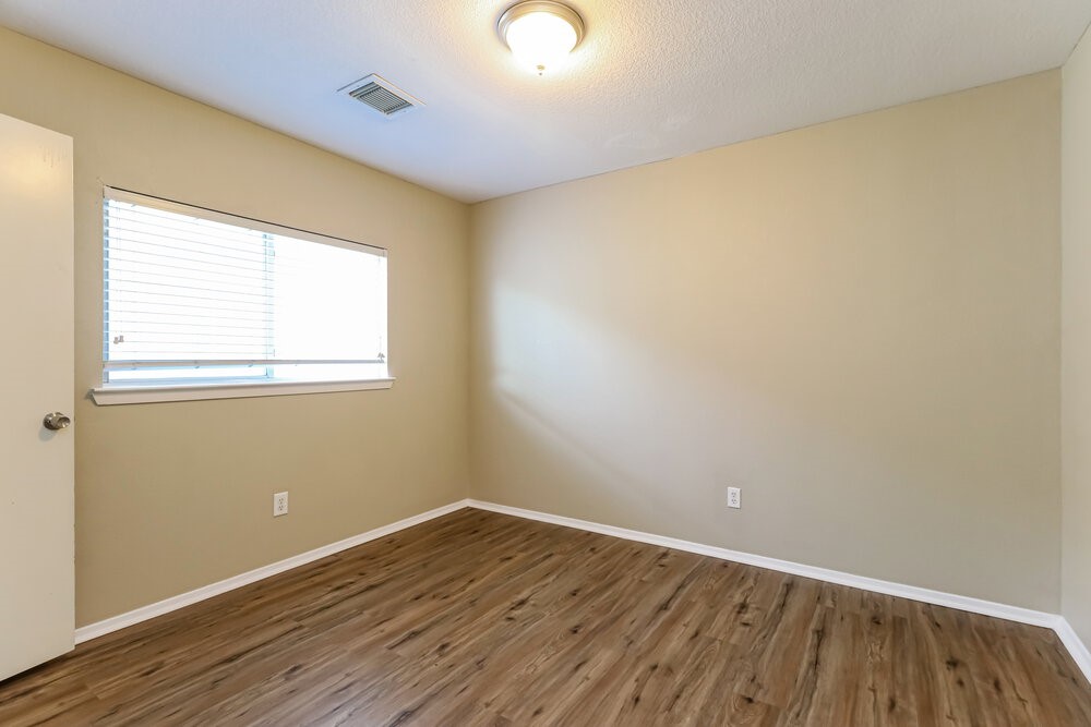 1207 Verde Trails Drive Houston, TX 77073 - Photo 14 of 17 an empty room with wooden floor and windows