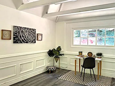 a view of a workspace with furniture and a window