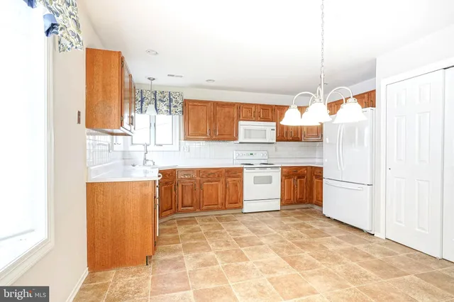 a large kitchen with a stove a sink dishwasher and a refrigerator