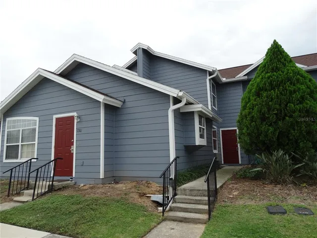 a small hut with a small yard and wooden fence