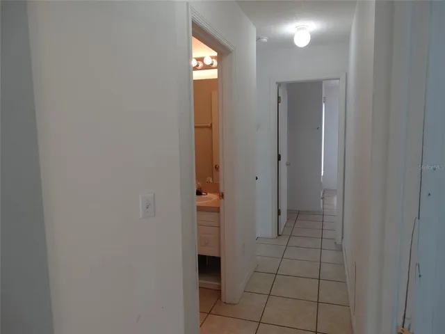 a view of an empty room with window and bathroom