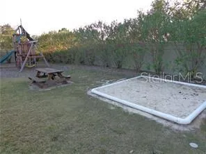 a view of swimming pool with table and chairs potted plants and palm trees